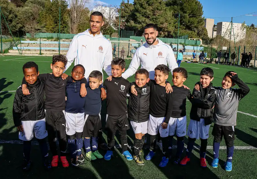 Photo de Greenwood et Maupay avec les joueurs du fc la castellane
